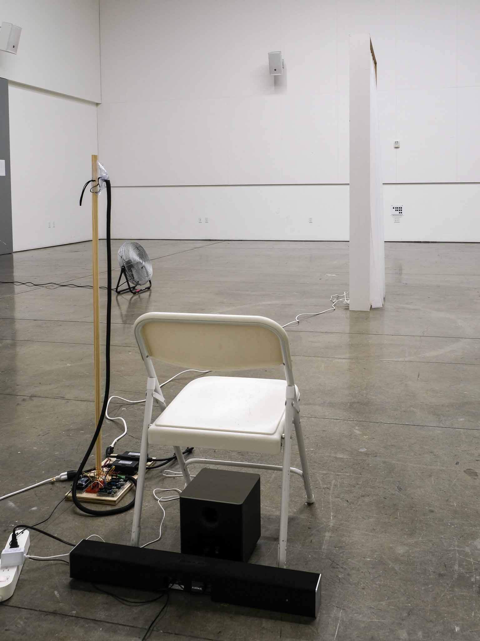 Calm The Storm installation with a chair, breathing sensor, fan, fabric, and speakers