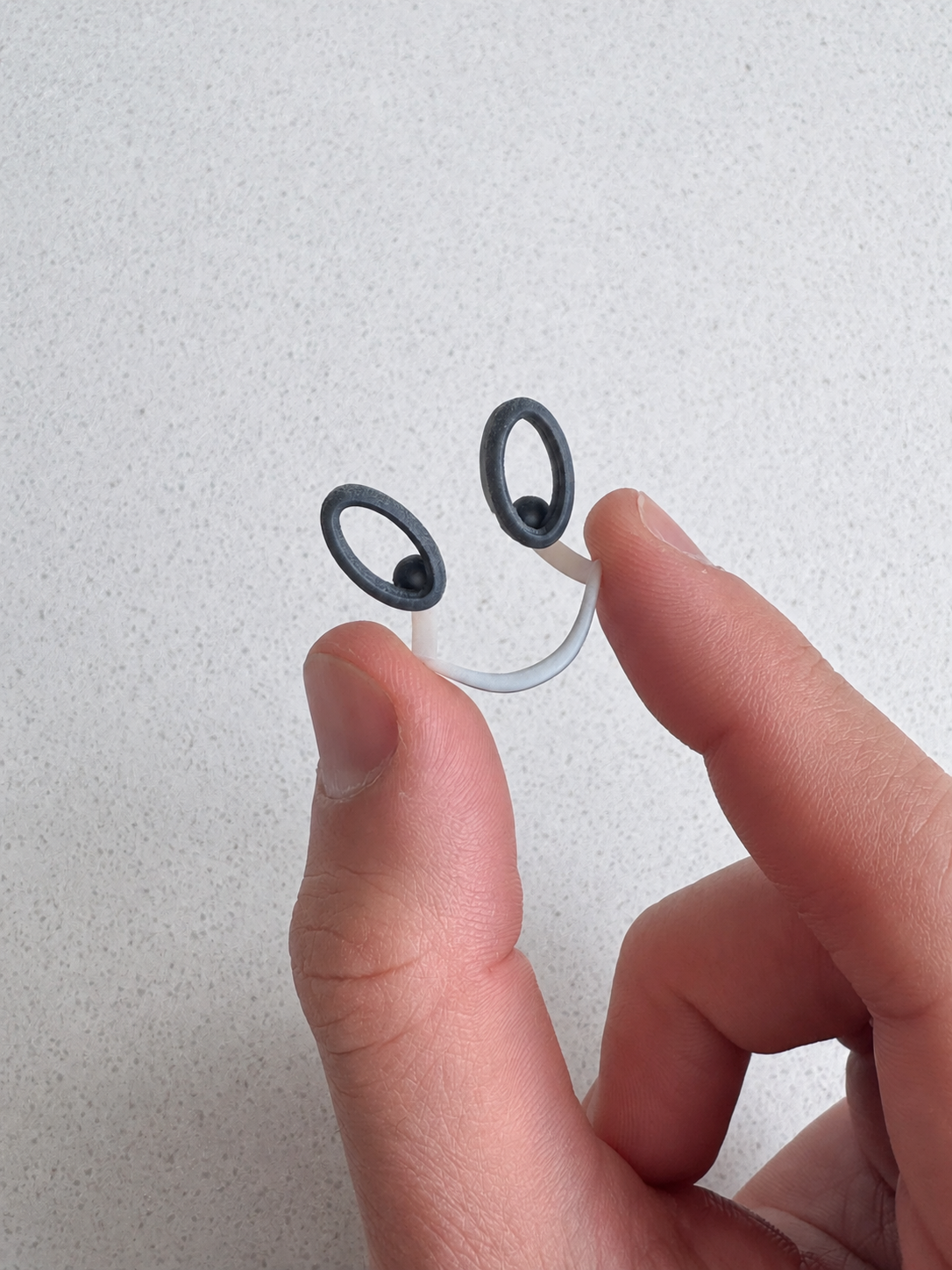 A small wearable form held between two fingers